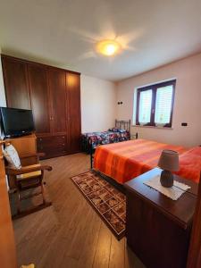a bedroom with a bed and a tv and a chair at la casa di simone in Torre Tre Ponti