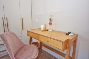 Alepochórion的住宿－Minerva Estate Corfu，一张带粉红色椅子和抽屉的木桌