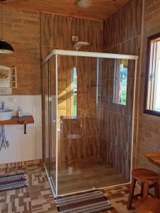 eine Dusche mit Glastür im Bad in der Unterkunft Chalés Bons Ventos - Chalé Estrela in São Bento do Sapucaí