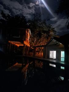 una casa di notte con un riflesso nell'acqua di Hotel Rural Café del Río a La Paz