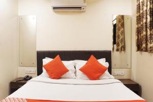 - un lit avec des oreillers orange et blancs dans l'établissement OYO Hotel paradise, à Mumbai