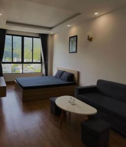 een kamer met een bed, een bank en een tafel bij Ami Mountain Sea DaNang Cozy Room - Large Windows, View Mountain in Da Nang