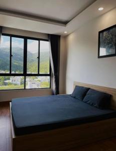 een slaapkamer met een groot bed en een groot raam bij Ami Mountain Sea DaNang Cozy Room - Large Windows, View Mountain in Da Nang