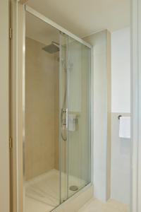 a shower with a glass door in a bathroom at Hotel des Victoires - Restaurant in Cannes
