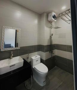 een badkamer met een toilet, een wastafel en een spiegel bij Ami Mountain Sea DaNang Cozy Room - Large Windows, View Mountain in Da Nang