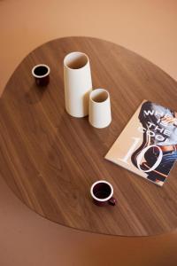 a wooden table with two cups and a magazine at Hotel des Victoires - Restaurant in Cannes