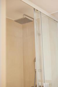 a shower with a shower head in a bathroom at Hotel des Victoires - Restaurant in Cannes