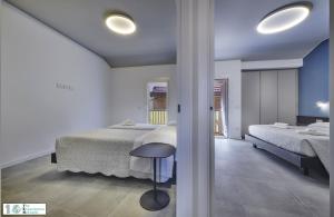 Un dormitorio con 2 camas y un taburete. en Casa Posta, en Varenna
