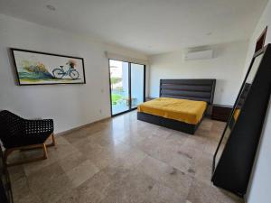 Un dormitorio con una cama y una silla dentro. en Villa 90 B Nayar, en Cruz de Huanacaxtle