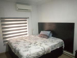 1 dormitorio con 1 cama con cabecero de madera grande en D'Island Hotel and Club, en Lekki