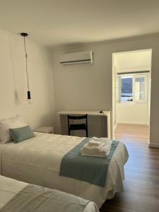 ein Schlafzimmer mit zwei Betten und einem Schreibtisch mit Fenster in der Unterkunft AL44 in Beja
