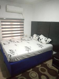 uma cama com almofadas pretas e brancas num quarto em D'Island Hotel and Club em Lekki
