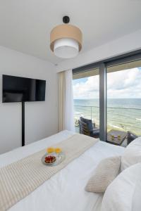 a bedroom with a bed with a view of the ocean at HS Apartamenty Hevenia Heaven widok na morze in Rewal