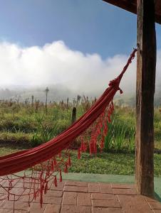 a hammock with a view of a field at Chalés Bons Ventos - Chalé Estrela in São Bento do Sapucaí