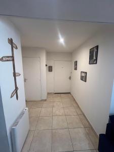 um corredor com paredes brancas e uma cruz na parede em Logement Bonheur 