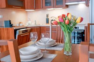 a dining room table with a vase of flowers and glasses at Apartmán u METRA, 4 hosté, parking free, blízko O2 arena in Prague