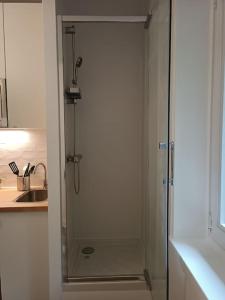 a shower with a glass door in a kitchen at Studio à 35 min du cœur de Paris in Saint-Cloud