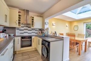 cocina con lavadora y comedor en Beautiful bungalow with parking and large garden, en Southend-on-Sea