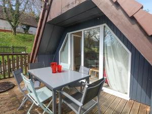 a table and chairs on the deck of a tiny house at Valley Lodge 44 in Callington