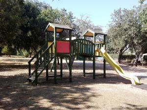 2 attrezzature per il parco giochi con scivolo in un parco di Nuraghe Ruiu Camping & Bungalow a Norbello