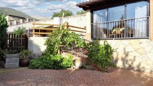 a house with a balcony and a brick patio at 5 bedrooms villa with private pool enclosed garden and wifi at Jerte in Jerte