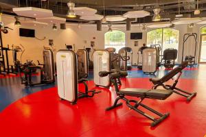 a gym with rows of exercise equipment on a red floor at Breathtaking Full Sea View Luxury Apartment JBR in Dubai