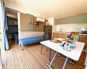 uma cozinha e uma sala de estar com uma mesa num quarto em Villaggio Acquamarina em Pisciotta