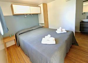 una habitación de hospital con una cama con toallas. en Villaggio Acquamarina en Pisciotta
