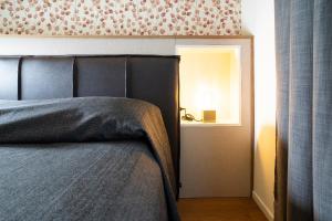een slaapkamer met een bed en een licht in een kamer bij Villino Milano in Milaan