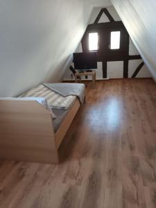 1 dormitorio con 1 cama y TV en el ático en Ferienhaus Valler, en Vallendar