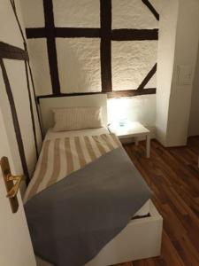 Cama en habitación con suelo de madera en Ferienhaus Valler, en Vallendar