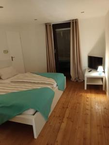 a bedroom with a bed and a desk and a television at Ferienhaus Valler in Vallendar
