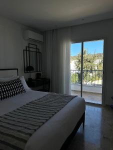 Misk Villa - Boutique Hotel & Spa في سيدي بو سعيد: غرفة نوم بسرير ونافذة كبيرة