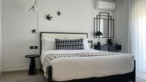 1 dormitorio con 1 cama con edredón blanco y negro en Misk Villa - Boutique Hotel & Spa, en Sidi Bou Saïd