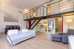 a living room with a couch and a staircase at Esclusivo loft con due camere da letto e terrazzo in Milan
