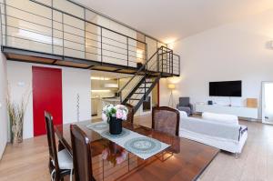 sala de estar con mesa de comedor y escalera de caracol en Esclusivo loft con due camere da letto e terrazzo, en Milán