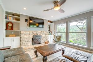 uma sala de estar com uma lareira de pedra e uma mesa em Austin Area Vacation Rental with Deck and Gas Grill! em Austin