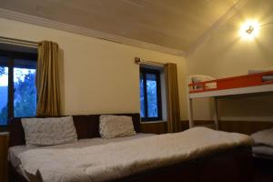 - une chambre avec un lit et des lits superposés avec des fenêtres dans l'établissement Batrasi Dak Bungalow, 
