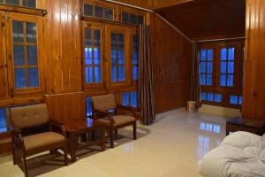 um quarto com uma cama, uma mesa e cadeiras em Batrasi Dak Bungalow 