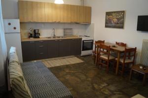 a kitchen with a sink and a table and a refrigerator at Tea's sea apartments in Siviri