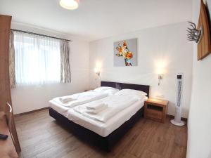 Un dormitorio con una gran cama blanca y una ventana en KitzviewTerrace, en Zell am See
