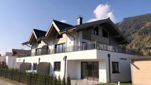 Casa blanca con balcón en la parte superior. en KitzviewTerrace, en Zell am See