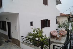 a white building with a patio with a table and chairs at Tea's sea apartments in Siviri