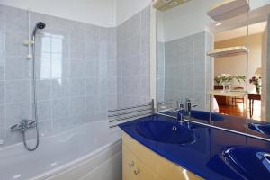 y baño con lavabo azul y bañera. en Magnifique appartement d'époque avec Vue Mer 4 personnes avec terrasse Le Port Nice en Niza