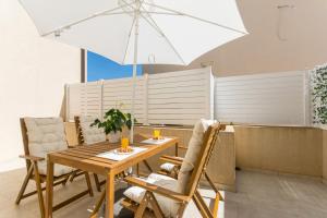 een eetkamer met een tafel en een paraplu bij Apartments D&D in Dubrovnik
