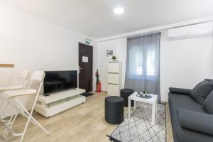 een woonkamer met een bank en een tv bij Apartments D&D in Dubrovnik