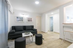 een woonkamer met een zwarte bank en een tafel bij Apartments D&D in Dubrovnik