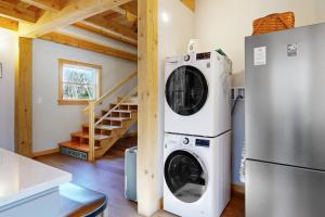 a washer and dryer in a kitchen next to a refrigerator at Cooper Cottage in Boothbay Harbor