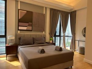 a bedroom with a large bed with a large window at Sentral Suites Kl Sentral By Luxe Home in Kuala Lumpur +94 photos