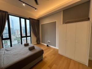 a bedroom with a large bed and a large window at Sentral Suites Kl Sentral By Luxe Home in Kuala Lumpur